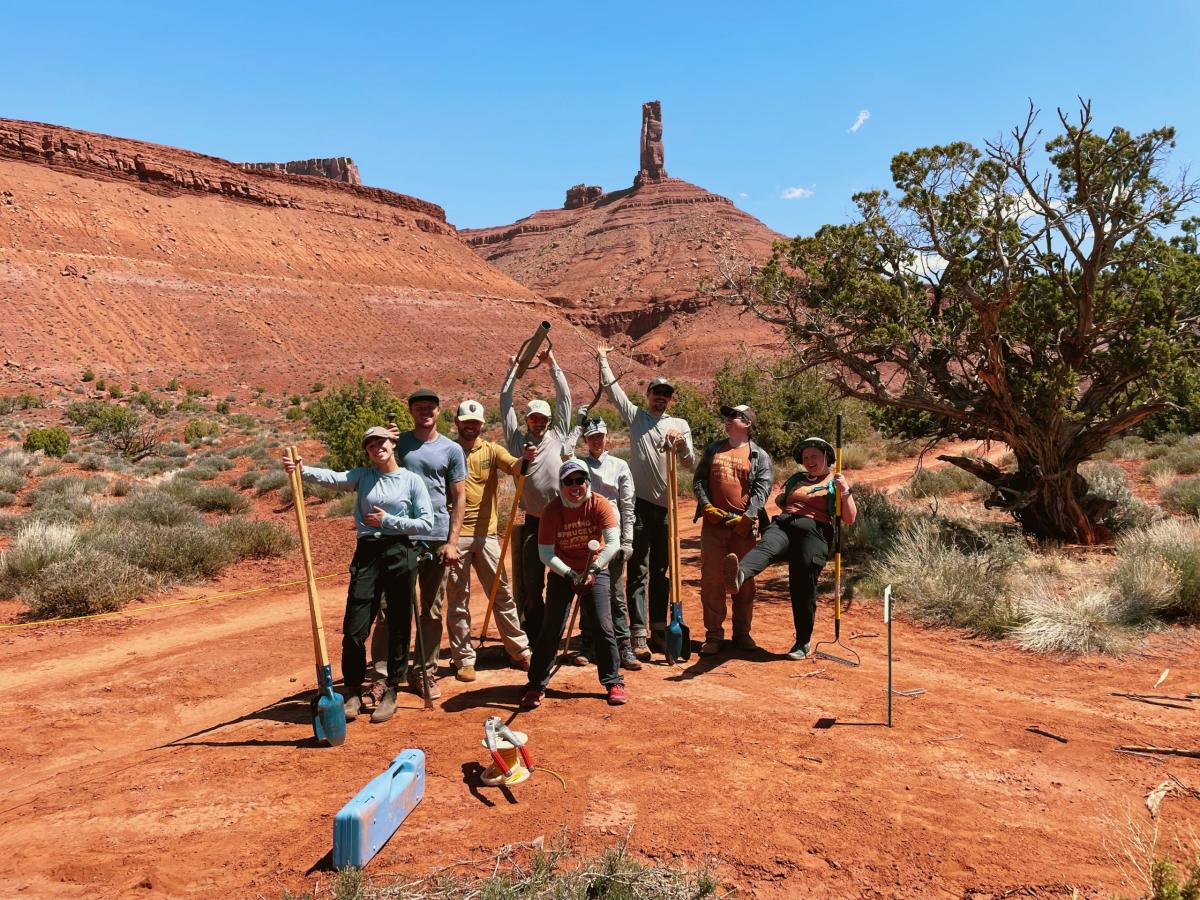 A group of people standing on the Castleton approach trail holding trail building equipment
