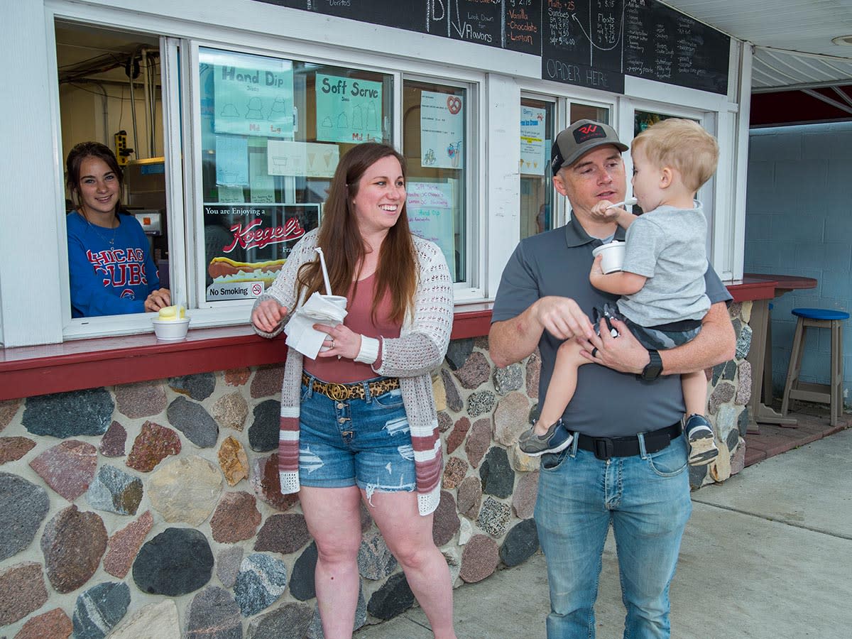 A family buying ice cream at a walk-up window at DJ's Tempting Treats in Steuben County.
