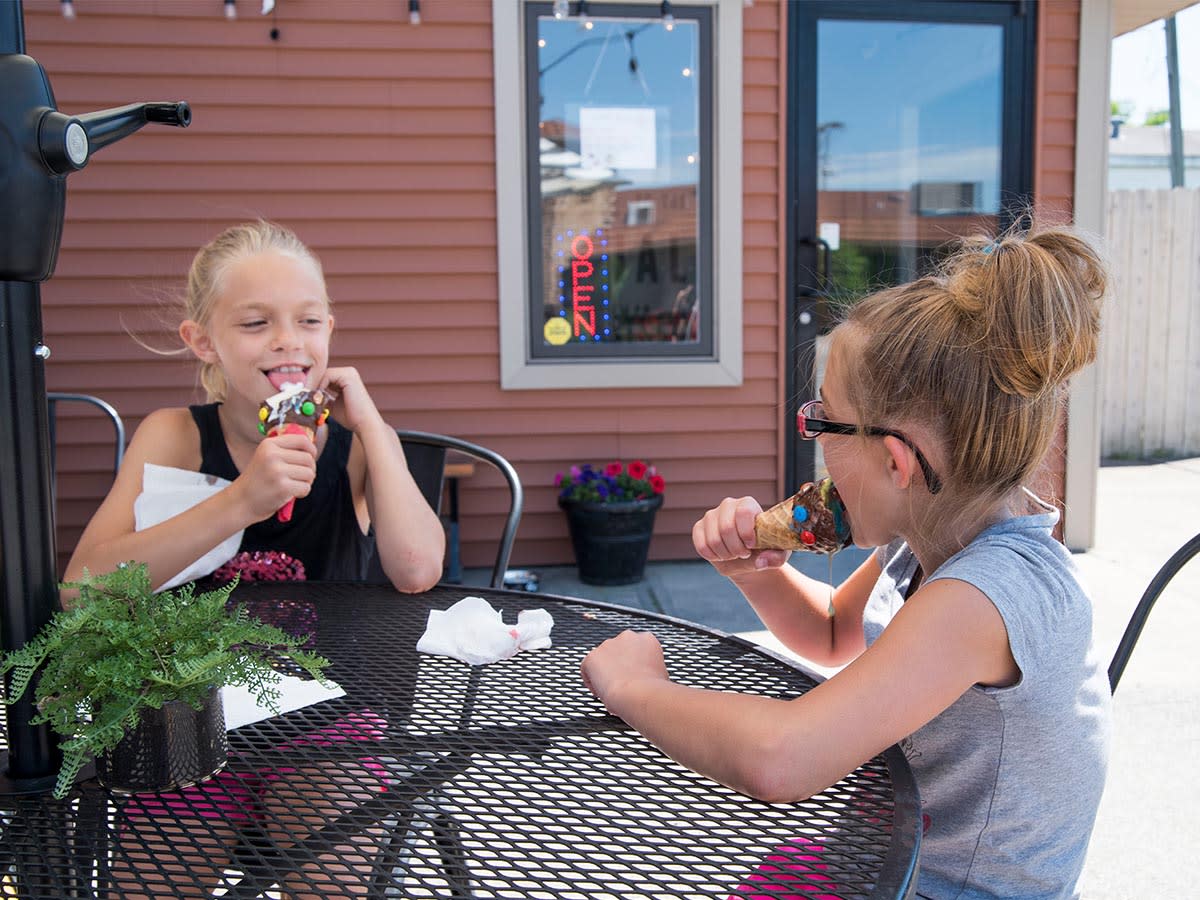 Two girls eating ice cream outside The Social Ice Cream in Steuben County.
