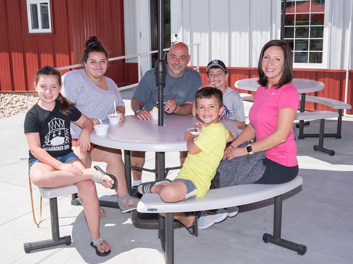 A family posing for a picture in front of Scoops Ice Cream in Steuben County.