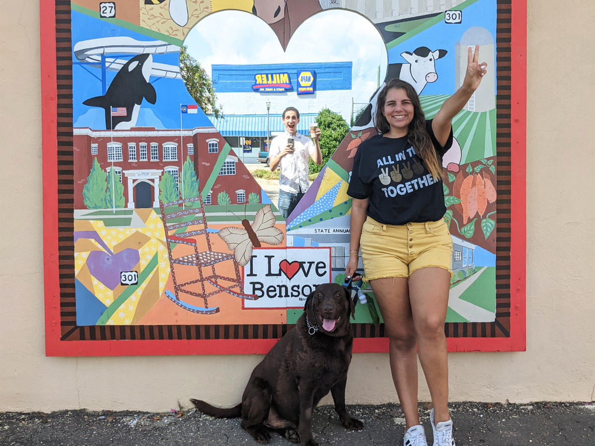 Woman Posing with Dog in Front of Benson Mural with Mirror in the Center