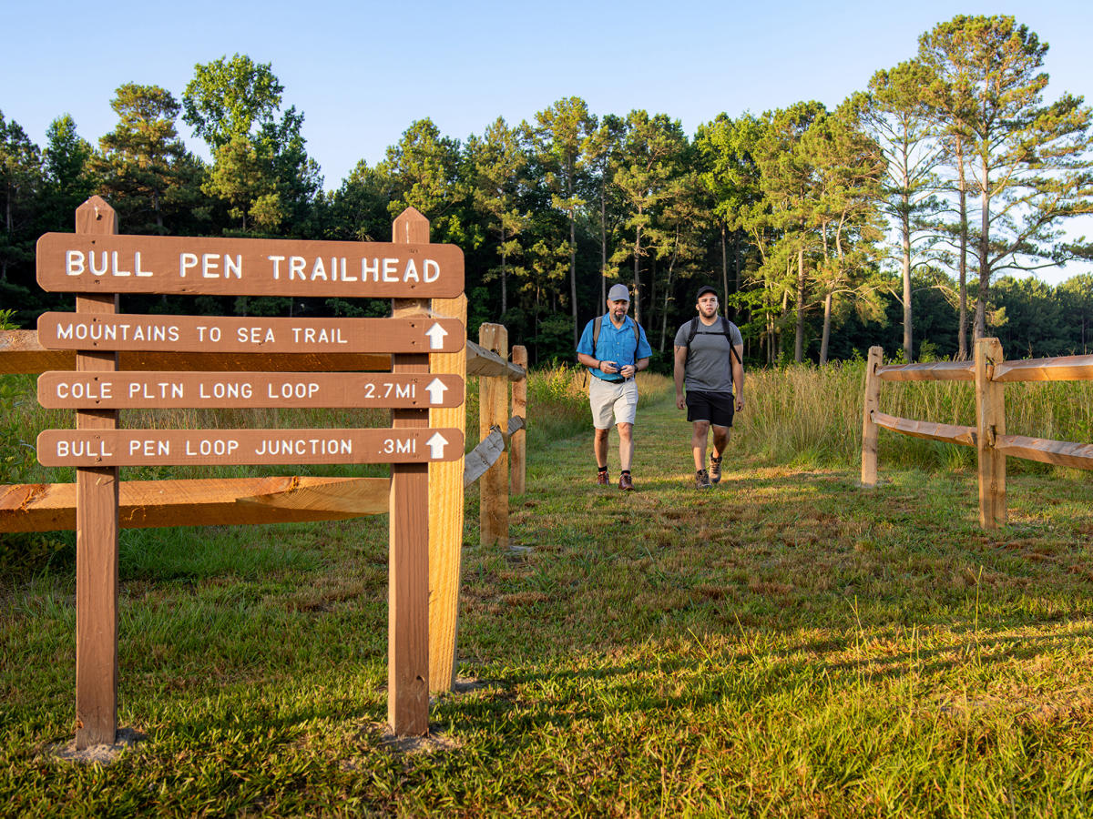Two hikers walking the Bull Pen trail head at Bentonville Battlefield.