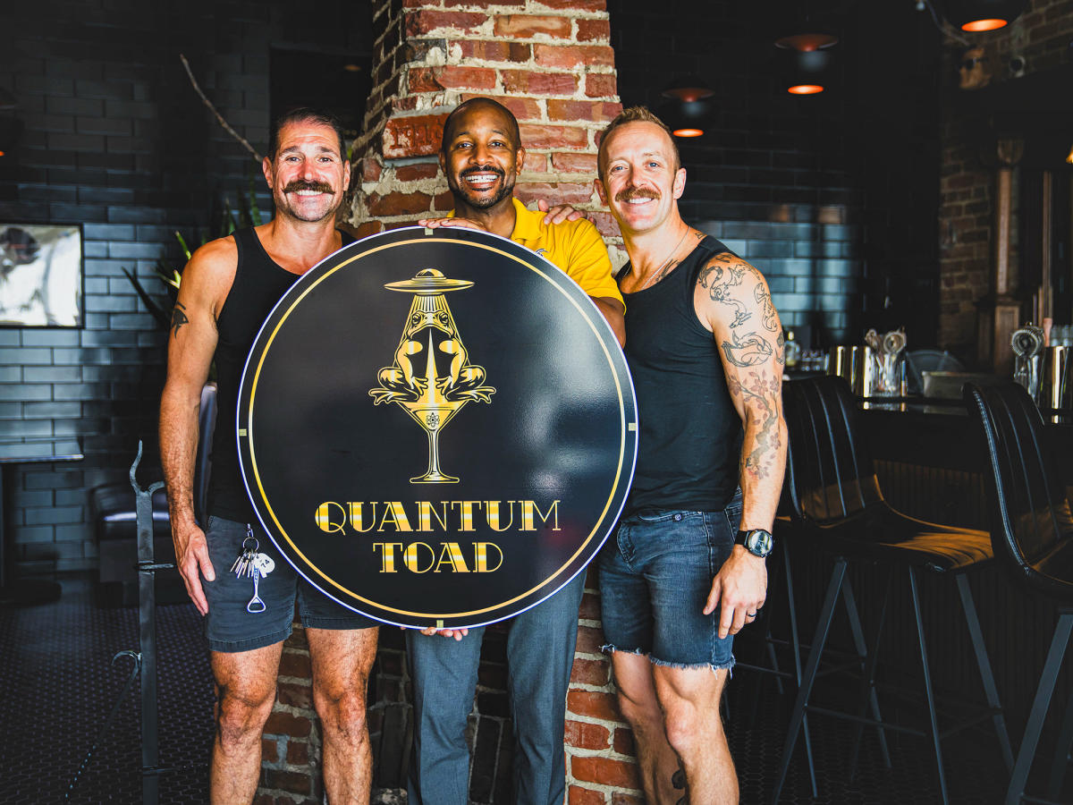 Quantum Toad Owners stand with Clayton Mayor and Bar Sign