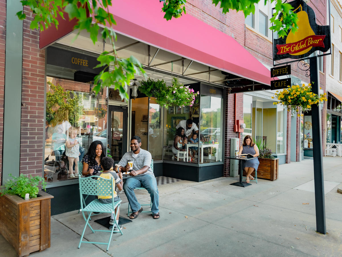 A family sits outside of the Gilded Pear while eating breakfast.