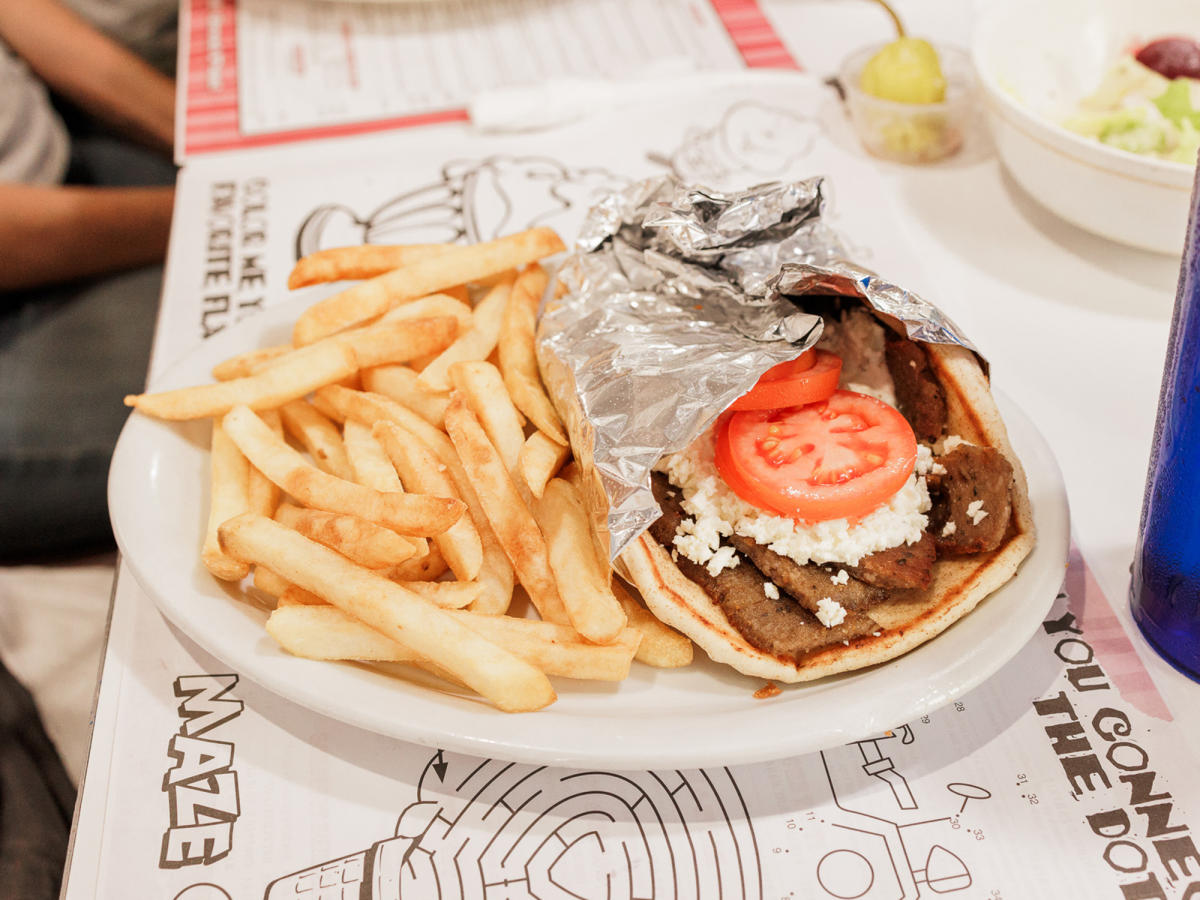 A gyro and fries sits on a white plate at D'icio's Parlour