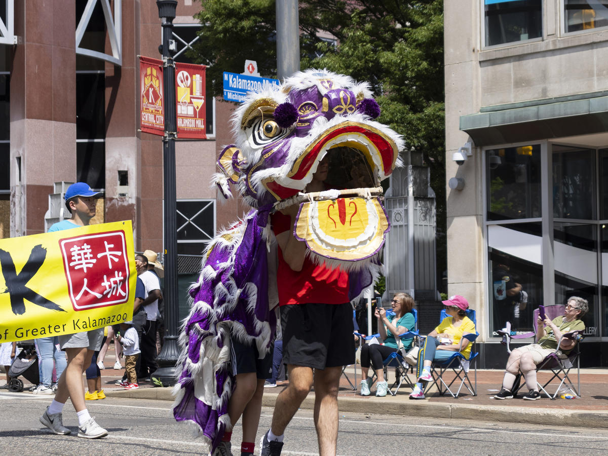 Two people walk around in a traditional Chinese Dragon suit during the Do Dah Parade during JumpstART Weekend in Kalamazoo.