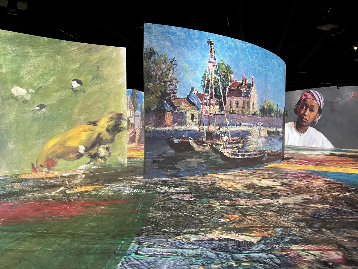 a gallery of large wall with digital paintings projected on to them