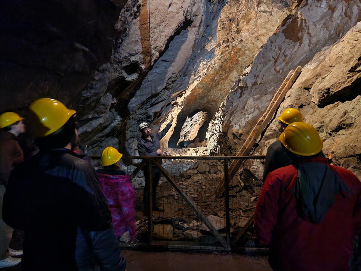 a tour guide speaks to a group in an underground mine