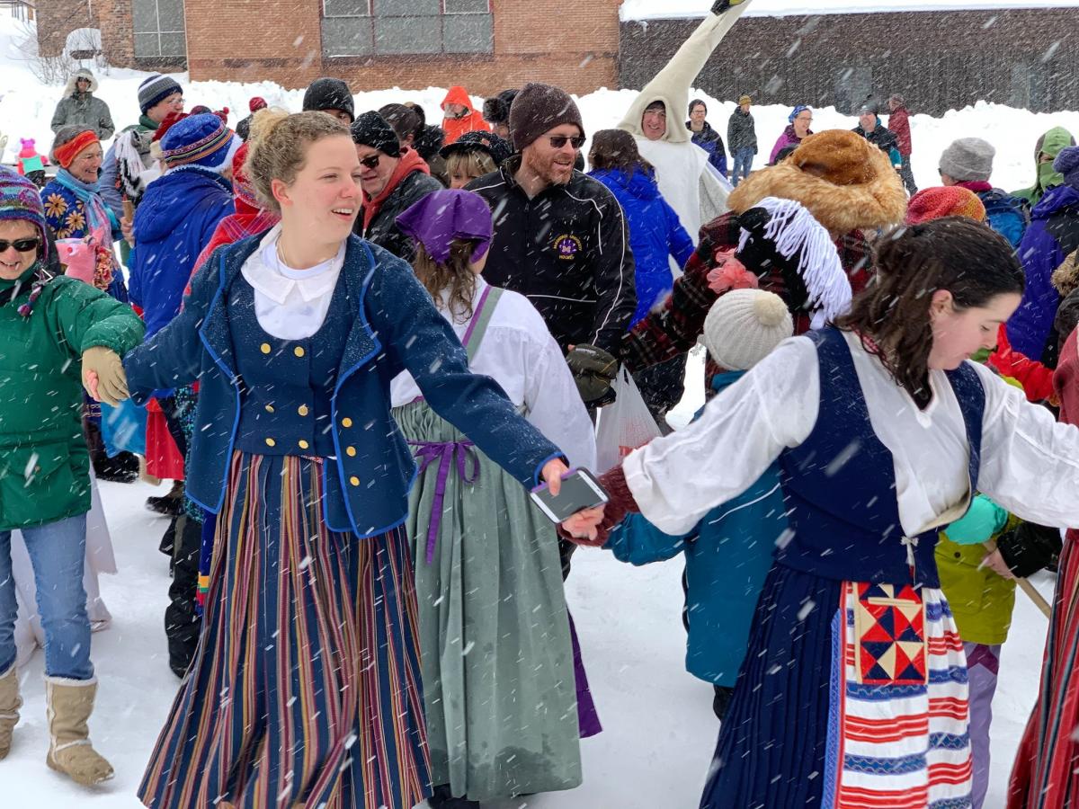Community members dressed in Finnish themed clothing participate in the Bear Spiral