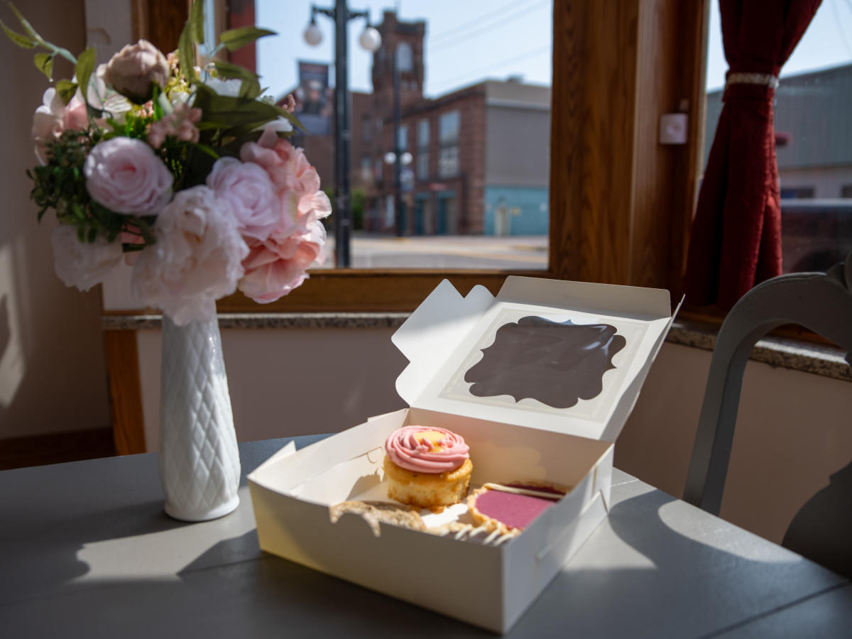 a box of pastries next to a bouquet of flowers
