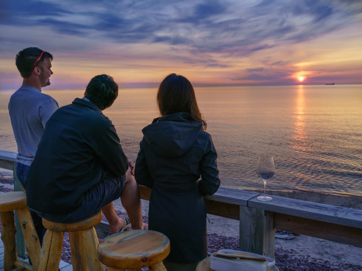 Friends enjoy a sunset over Lake Superior on the deck of the Fitzgerald Restaurant and Bar