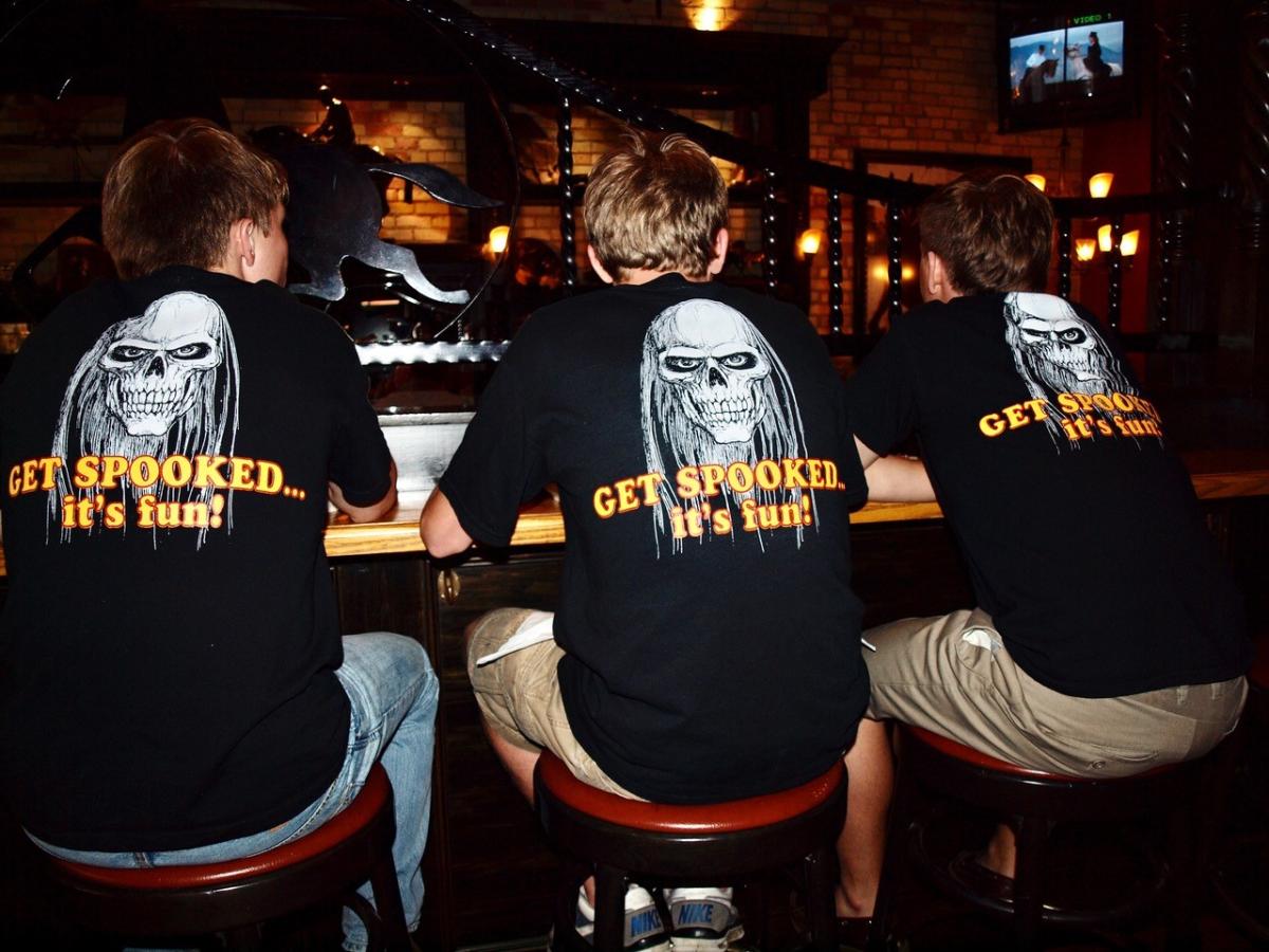 Young men wearing “Get Spooked. It’s Fun” t-shirts promoting Mackinac Island’s Haunted Theatre