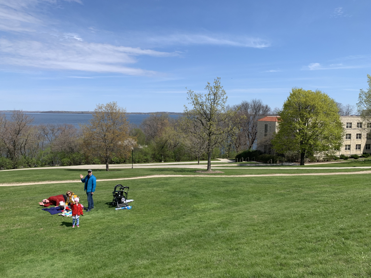 A family sets up a blanket on Observatory Hill in preparation for a picnic