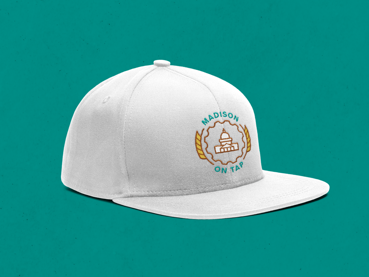 A white baseball cap with the Madison On Tap logo