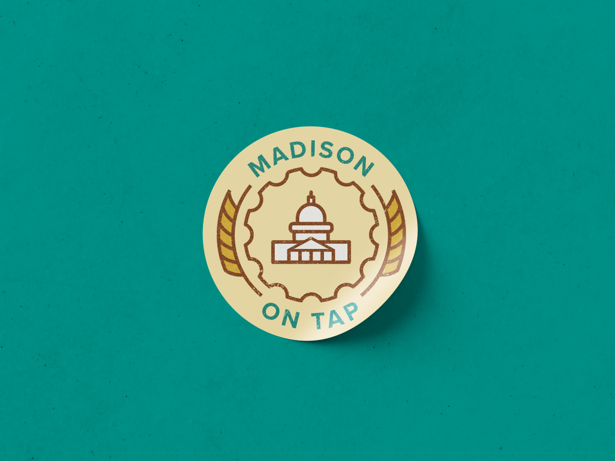 A round, yellow sticker with the Madison On Tap logo on it