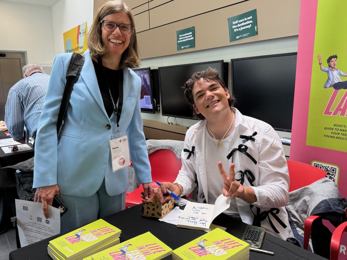 Professor Penny Cook picks up her signed copy of Rossi Griffin’s book