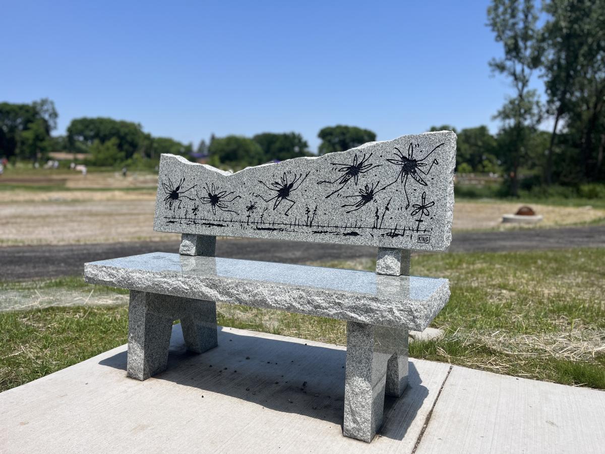 Stone granite bench with engraved black fireflies.