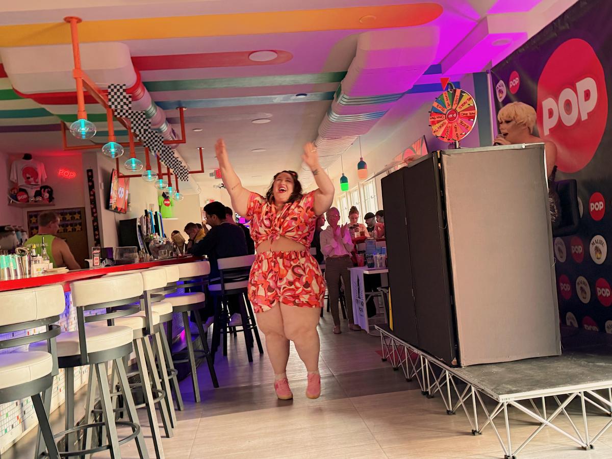 Alysse Delasandro raises her arms while participating in drag bingo at POP in Milwaukee.