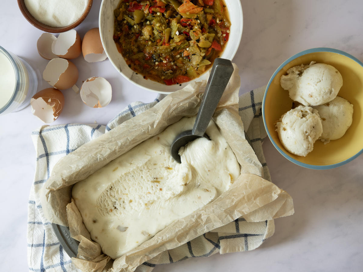 A top-down view of a white marble surface with several ingredients and tools for making ice cream.