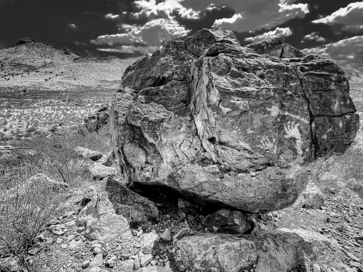 An isolated boulder in southern New Mexico includes hands,