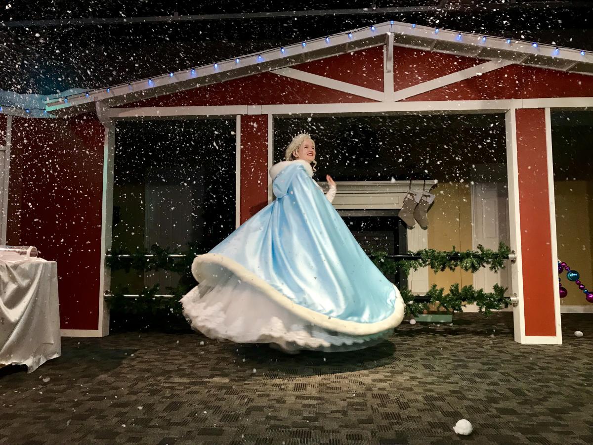 The Snow Queen dances in the snowfall during Santa's Magic at the Omaha Children's Museum.