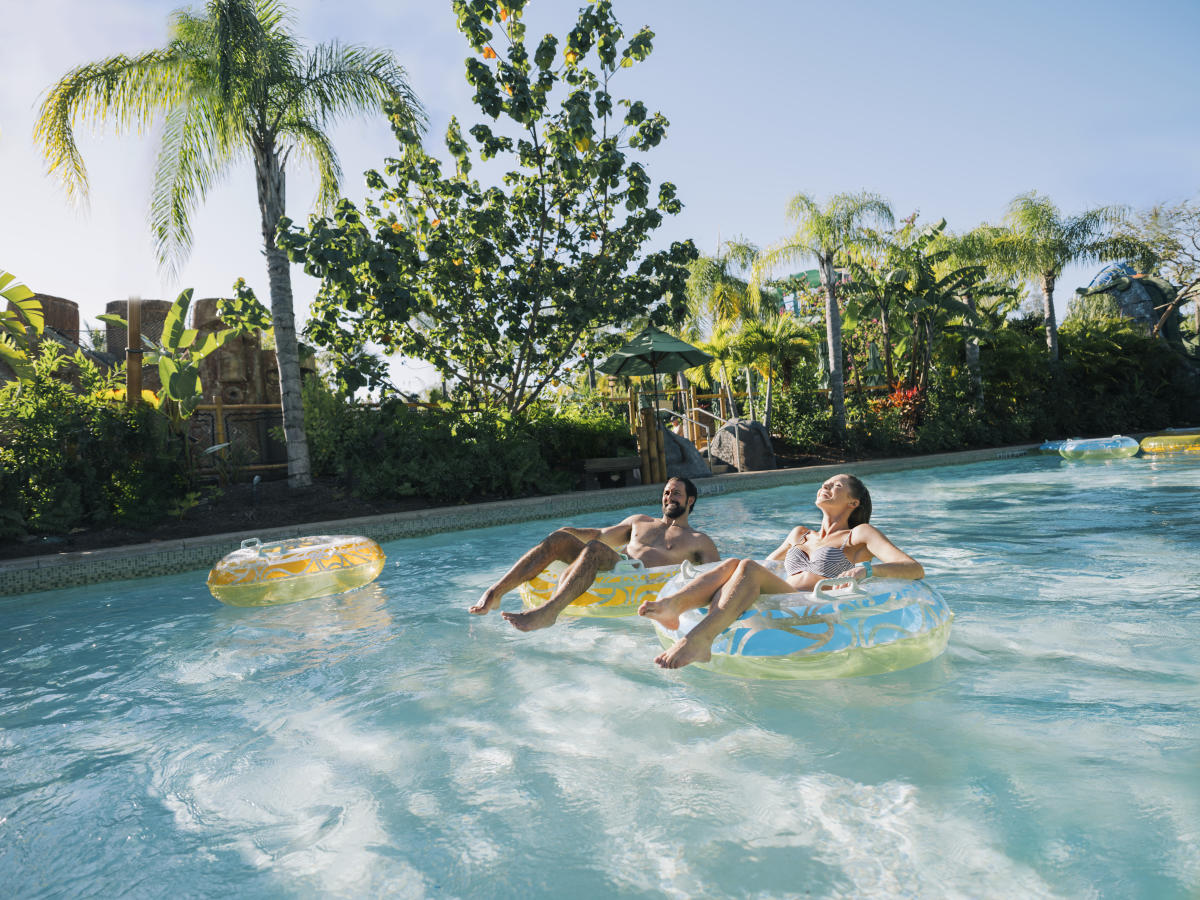 A couple floating in inner tubes on a lazy river in Universal's Volcano Bay.