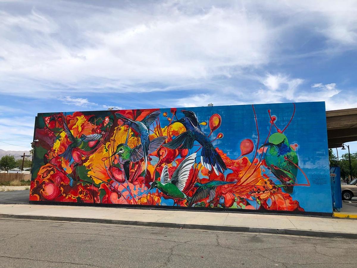 Colorful mural with hummingbirds and paint splatter