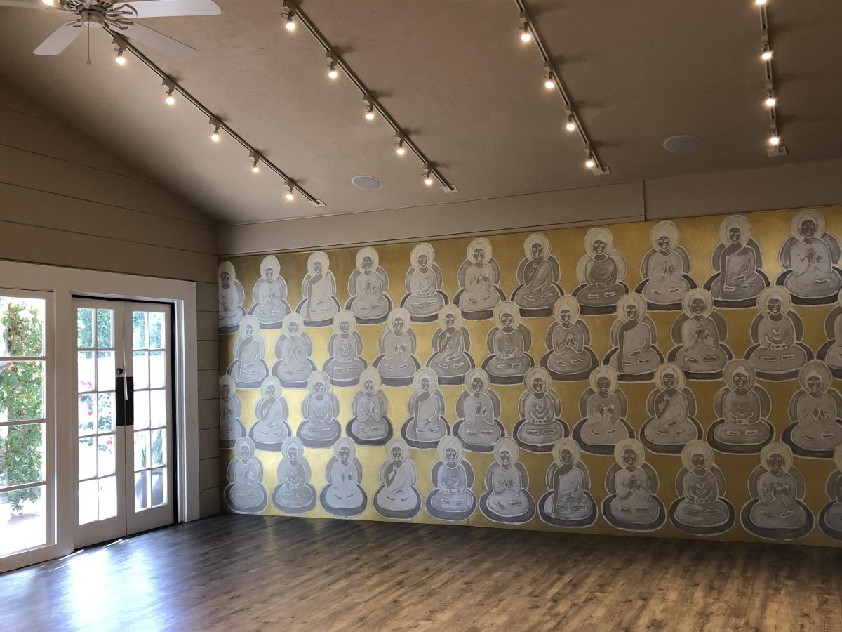 A yoga studio at La Quinta Resort & Spa with a gold and silver mural of Buddhas.