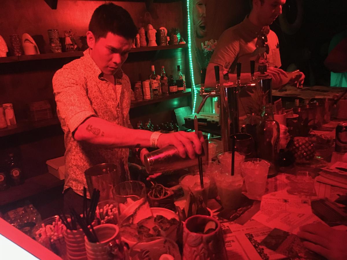 A bartender pours a drink at a secret tiki bar at Coachella Valley Music & Arts Festival