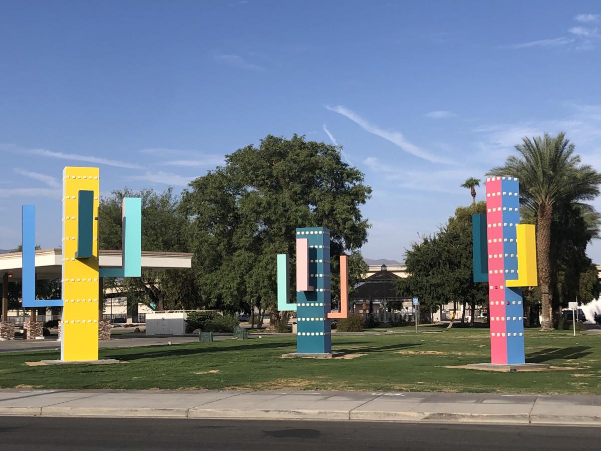 Three rectangular shaped and colorful cacti sculptures that range in height from 14 to 20 feet stand in a grassy area in downtown Indio next to the Indio Chamber of Commerce.