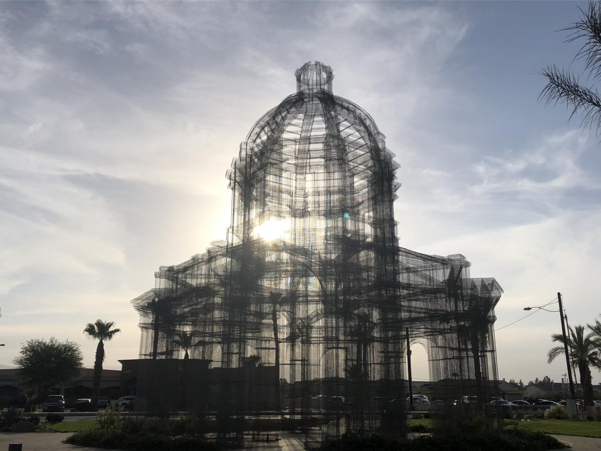 A 54 foot wire mesh sculpture of a Neoclassical building with a dome roof sits at a corner in downtown Coachella.