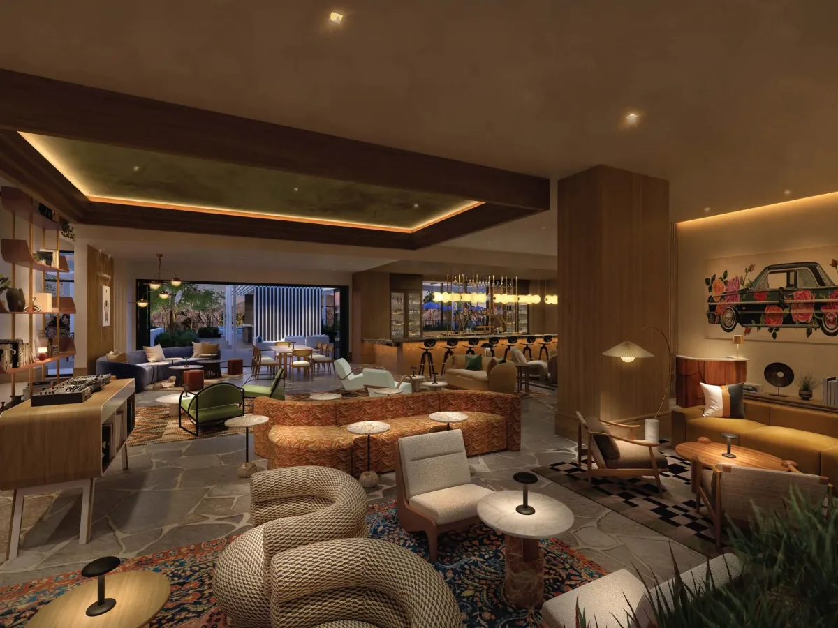 Luxuriously designed interior of a spacious lounge with dim ambient lighting, featuring a mix of modern and retro furniture, decorative rugs, and a bar area in the background, complemented by wall art depicting a vintage car.