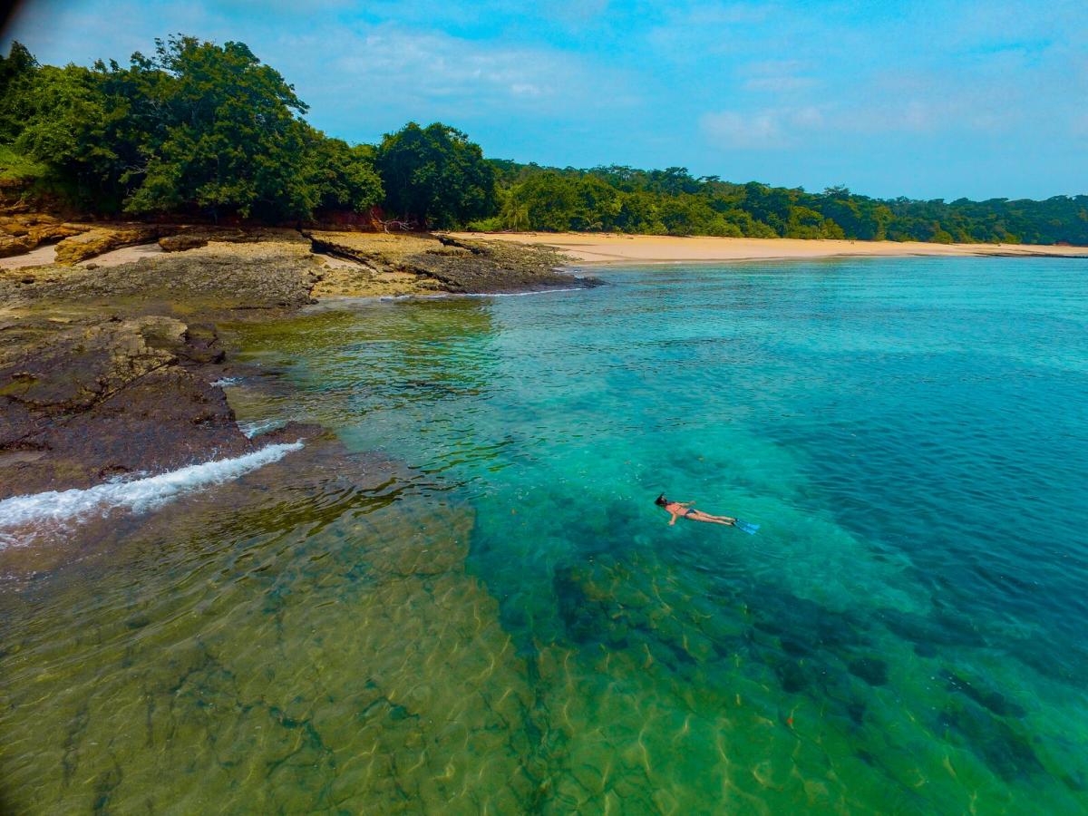 Woman snorkeling in blue water and blue sky.