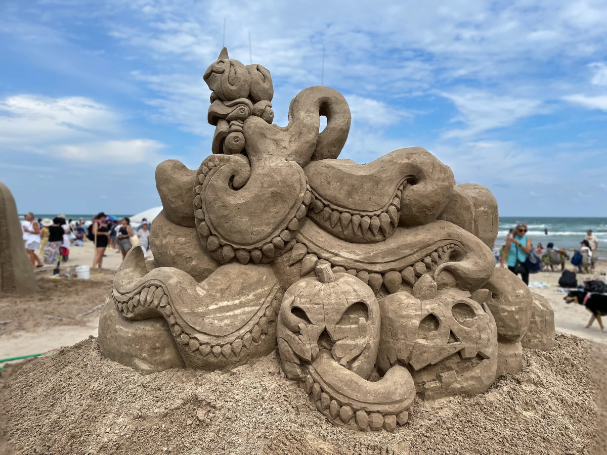 Sand sculpture showing octopus arms going through jack o' lanterns