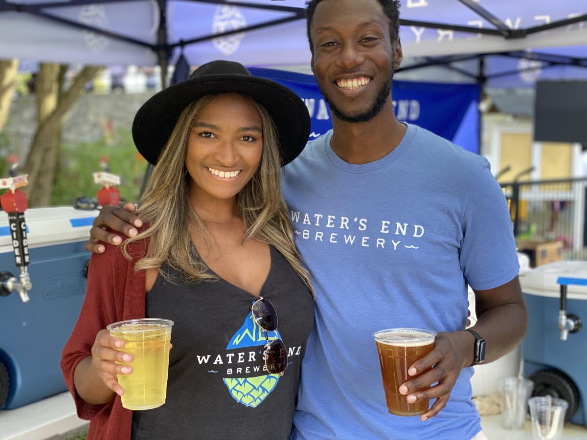 Two African American's wearing "Water's End" Beer Garden shirts holding beer.