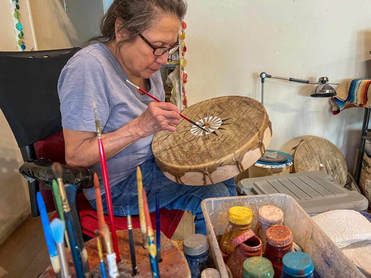 artist sonja holy eagle painting drums at dakota drum company in rapid city, sd