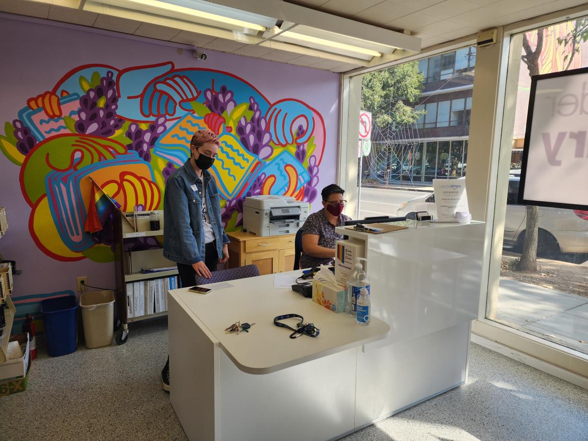 A reception area with colorful murals and friendly greeters