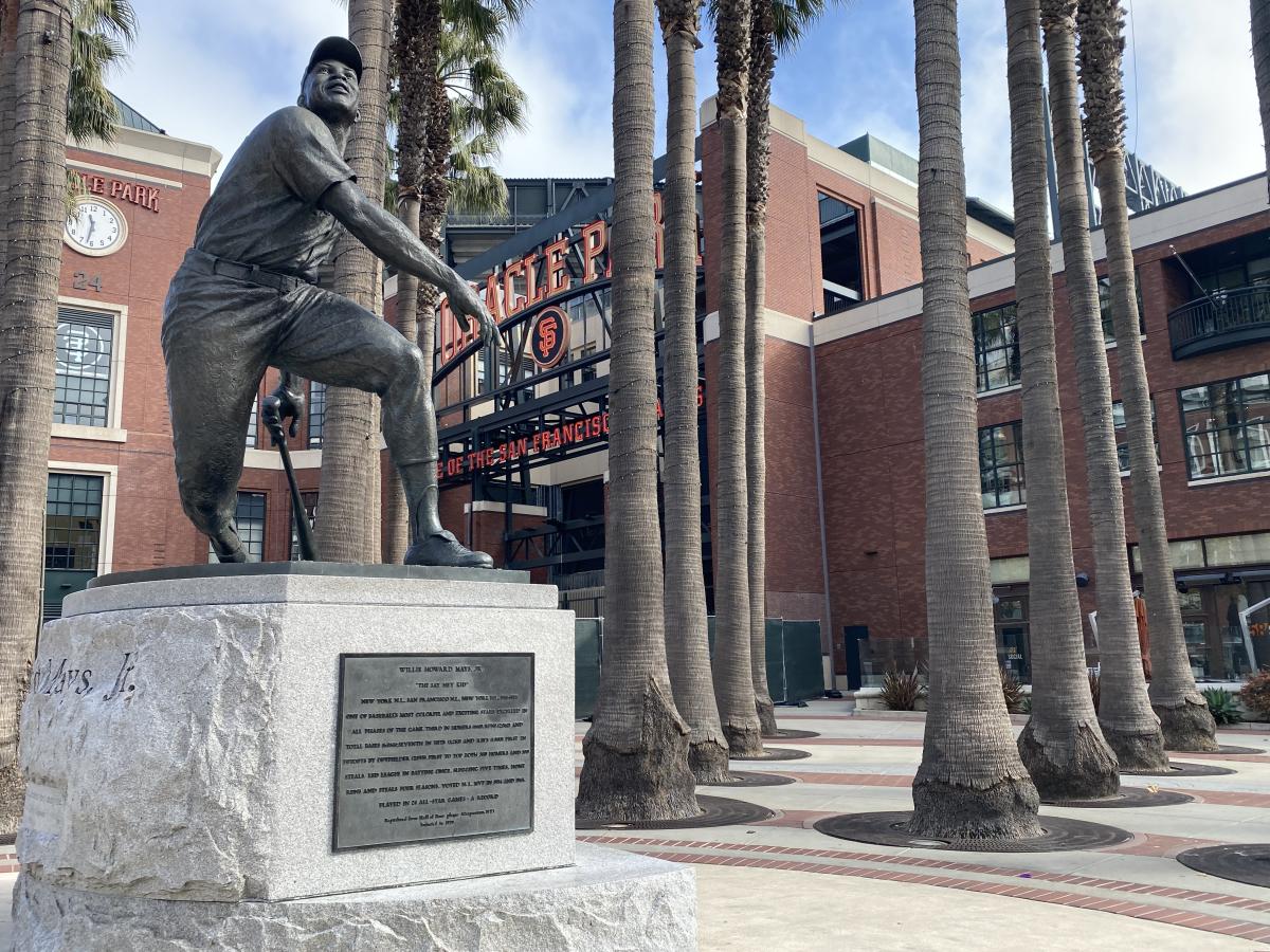 A bronze statue depicting baseball player Willie Mays in a post-swing stance at home plate