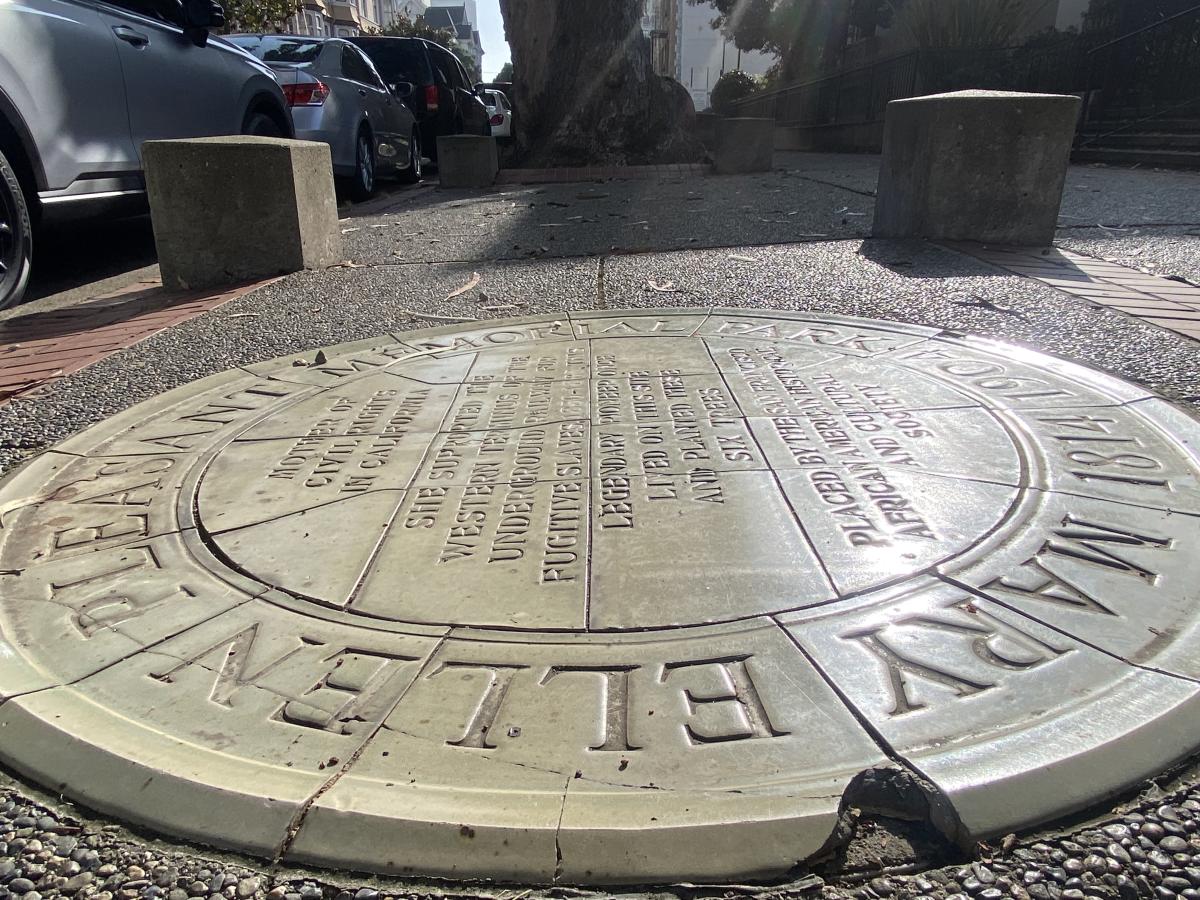 A large circle of granite embedded in the ground and engraved with the story of Mary Ellen Pleasant