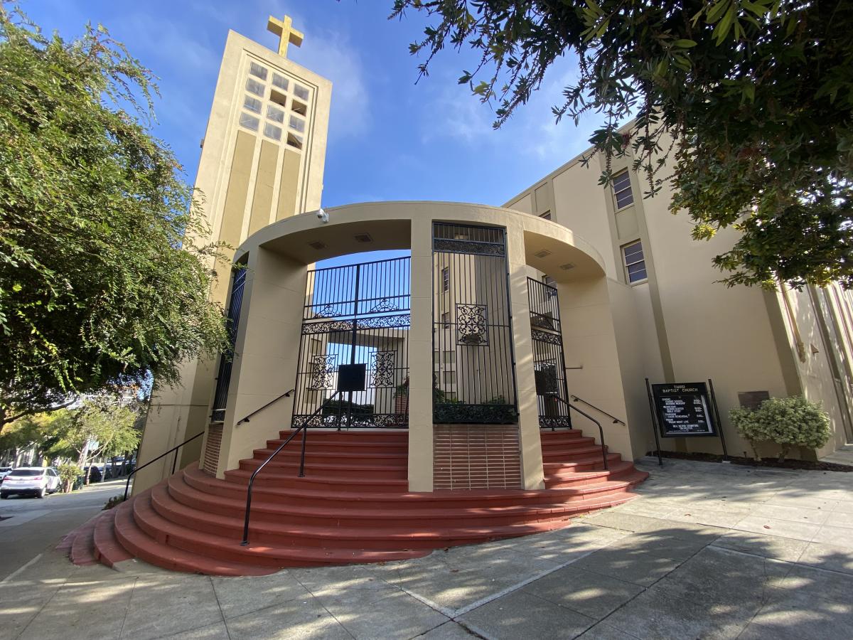 Red steps lead up to an entrance rotunda and large steeple welcoming visitors to Third Baptist Church