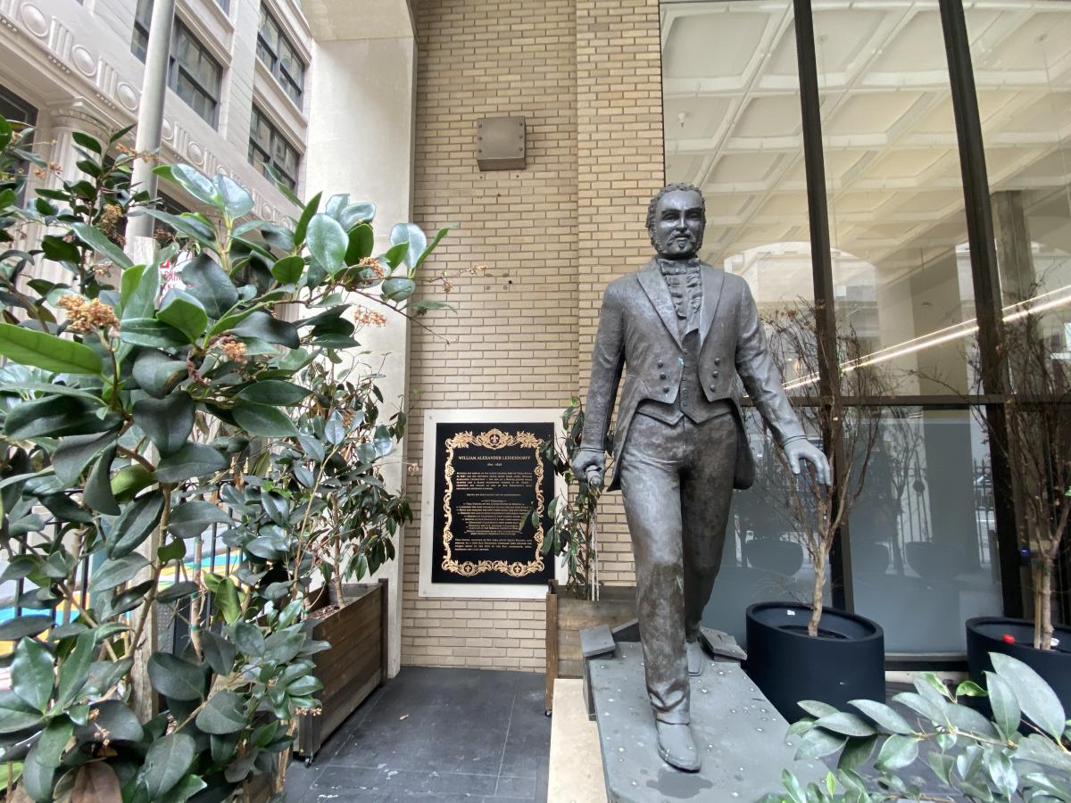 A bronze statue depicting William Alexander Leidersdorff, an African American man dressed in an 1800s suit, striding toward the viewer