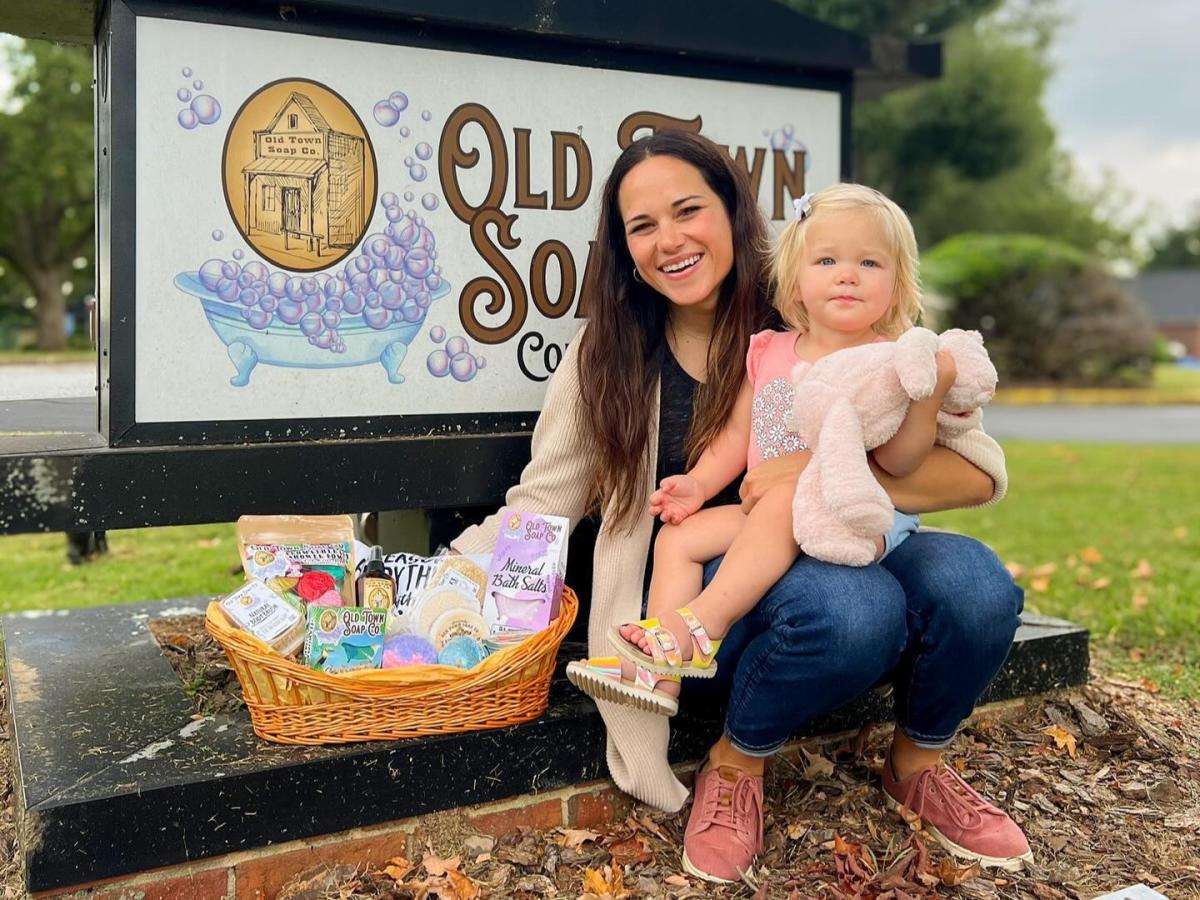 Mom and kid in from of Old Town Soap Co. Sign
