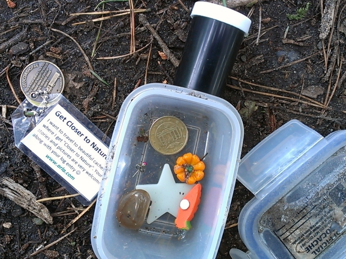 two geocache containers containing trinkets