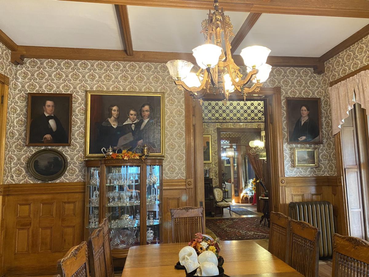 1900s victorian dining room filled with family portraits