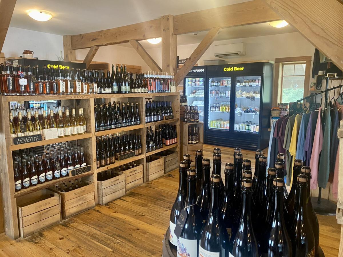 Finger Lakes Cider House store with alcohol, clothing, coolers and a rustic wooden feel