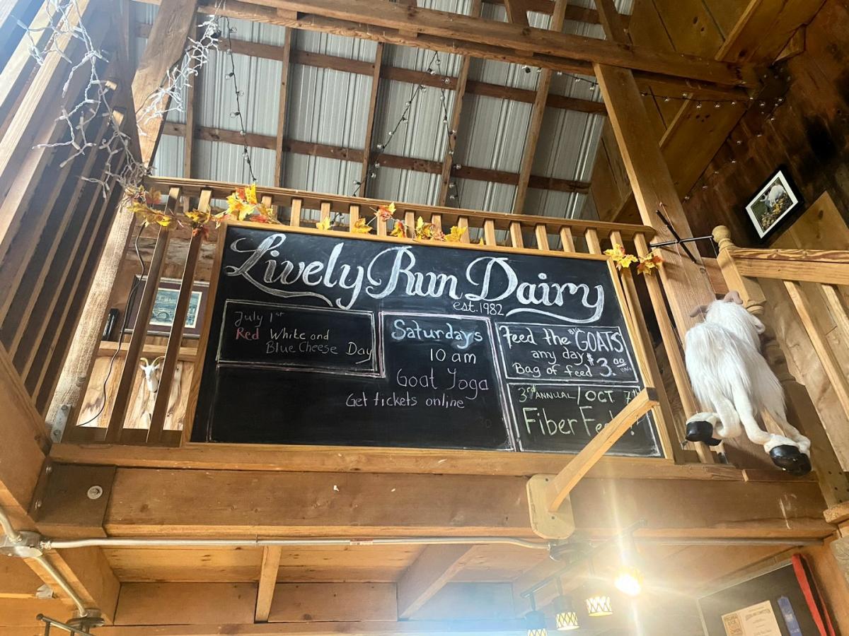 Chalkboard sign for Lively Run Dairy in a dimly lit barn