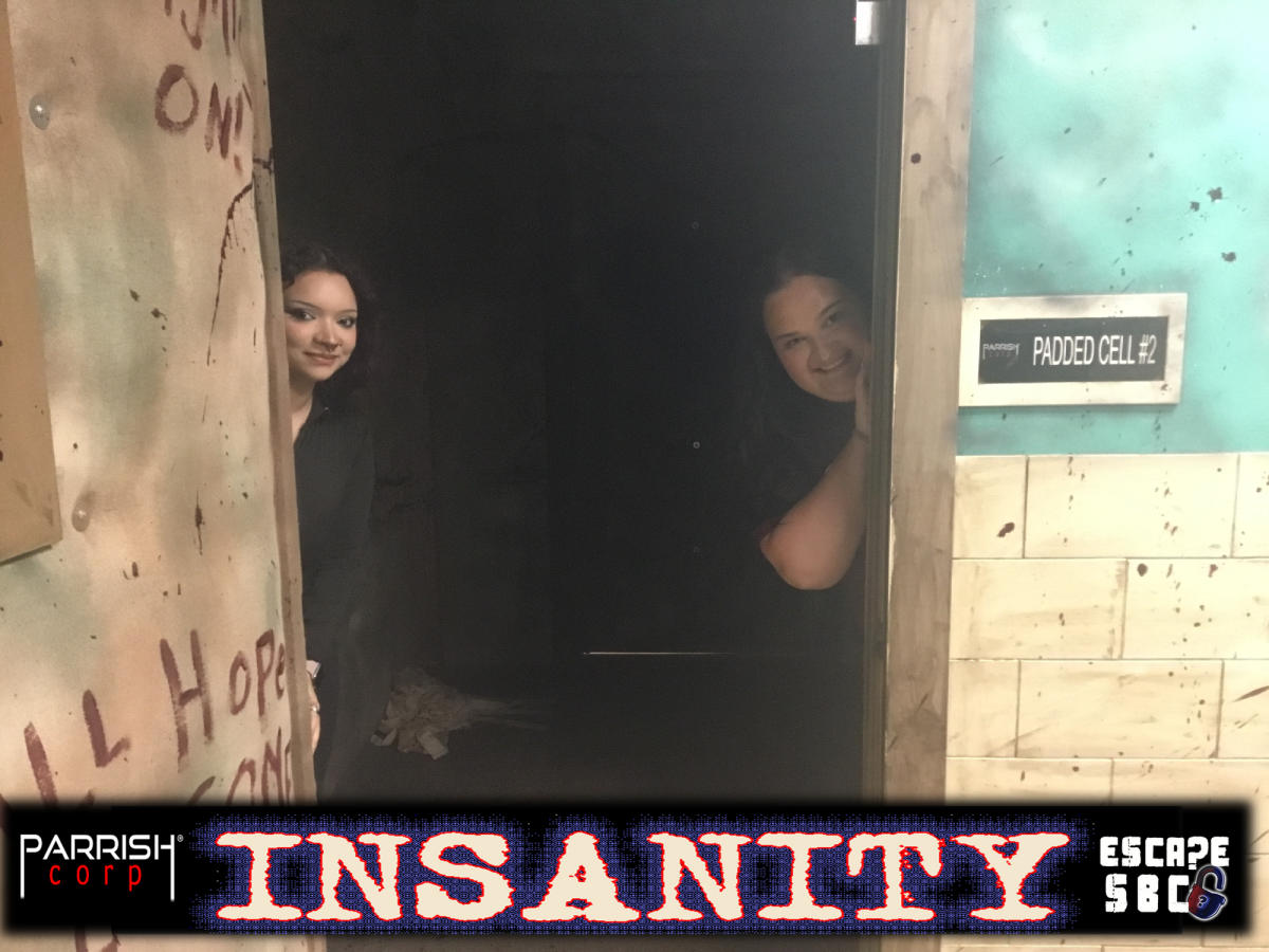 A photo of one of two people in Escape SBC's Insanity Room with the word "Insanity" at the bottom of the image