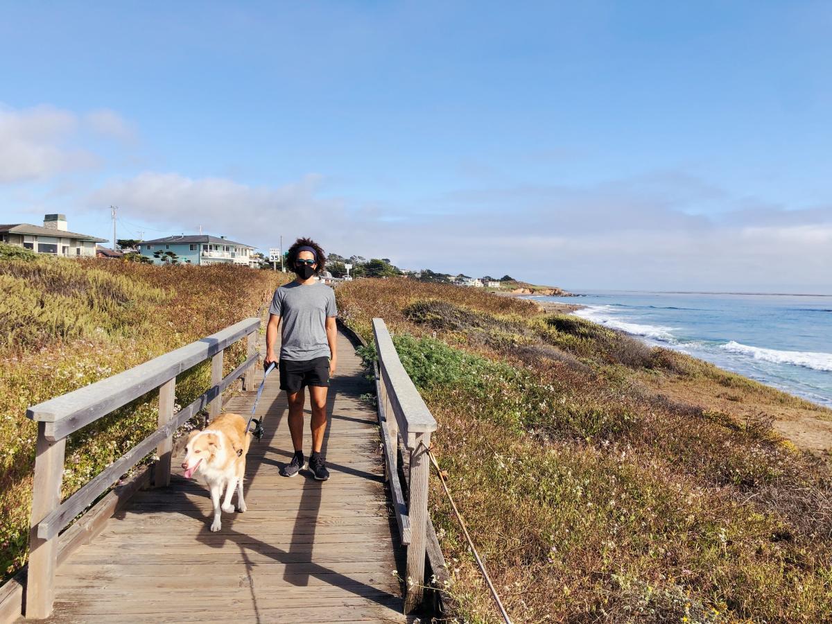 A man walking his dog along a boardwalk in Cambria in SLO CAL