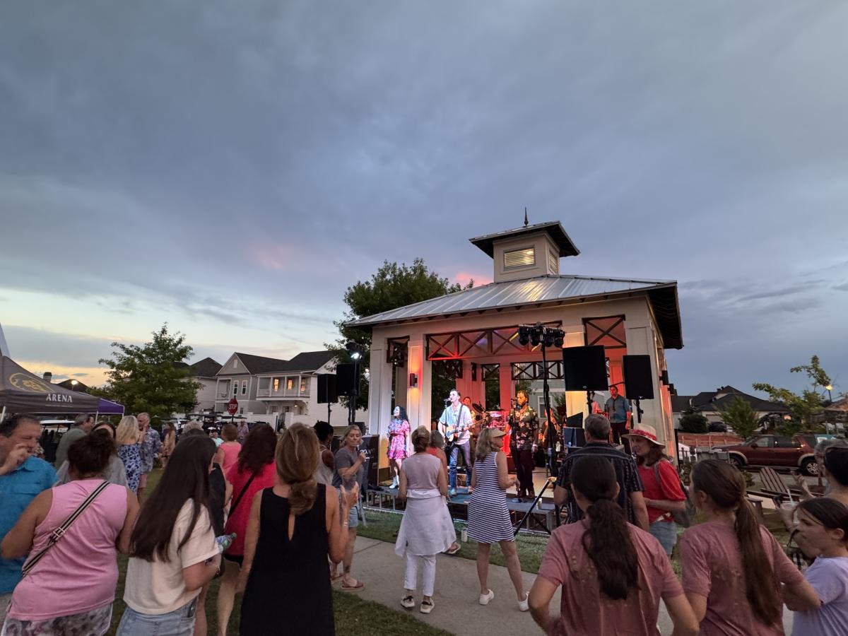 A crowd gathers in front of the performance stage in Terra Bella Village.