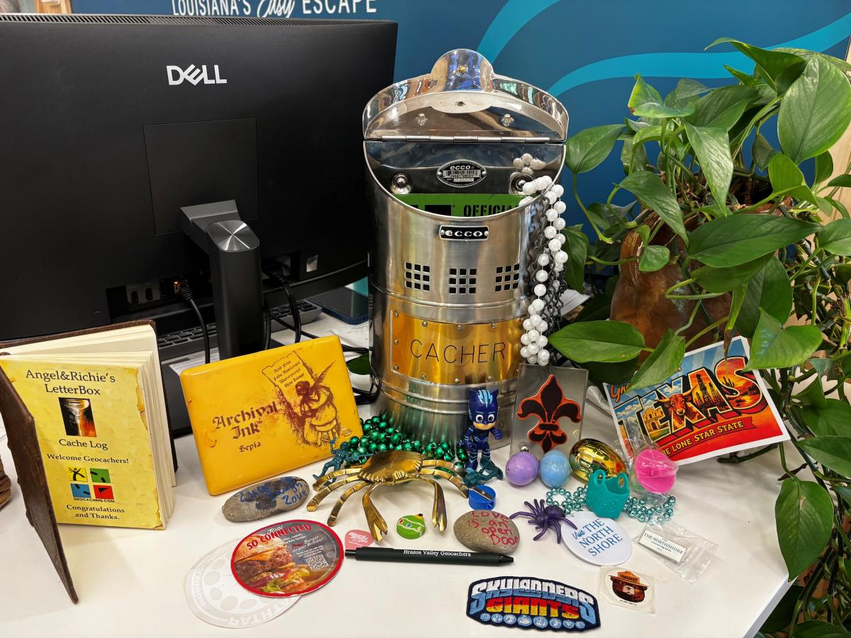 Geocaching container and travel trinkets displayed inside the Visit The Northshore Visitor Center in Mandeville, Louisiana.